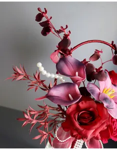 Stunning artificial wedding bouquet featuring deep red roses and calla lilies with pearls.