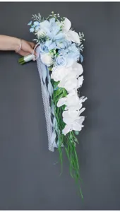 Nahaufnahme des kaskadenartigen Brautstraußes mit blau-weißen künstlichen Blumen und Band.