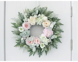 Close-up view of artificial peony and rose floral wreath hanging on door, elegant home decor.