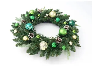 Weihnachtskranz Detail mit grünen Tannennadeln, goldenen und grünen Kugeln sowie Zapfen.