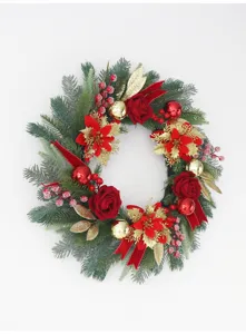 Detail view of artificial Christmas wreath with red roses, gold baubles and festive berries.