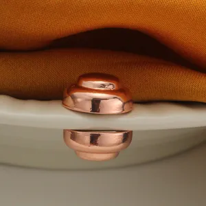 Nahaufnahme des roségoldenen magnetischen Kleiderverschlusses, ideal für die Ärmel.