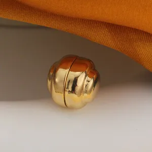 Nahaufnahme des goldenen magnetischen Druckknopfes, die glänzende Metalltextur zeigt.