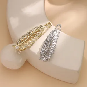 Detailed close-up of exquisite leaf-shaped pearl rhinestone brooch pins in gold and silver.
