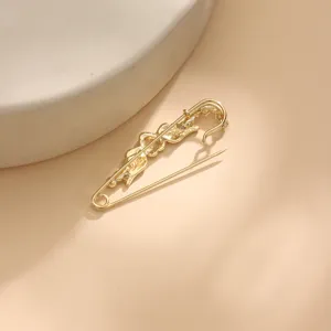 Gold metal safety pin brooch featuring an ornate snake design for scarves and shawls.