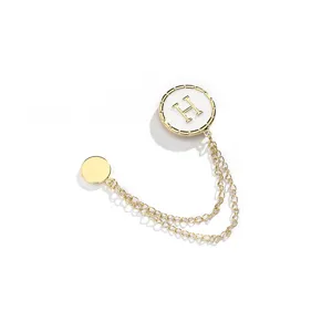 Gouden magnetische kledingclip met wit H-logo en stijlvolle dubbele ketting voor broeken.