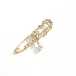 Gold rhinestone safety pin brooch with pearl pendant, elegant shawl and scarf buckle accessory.