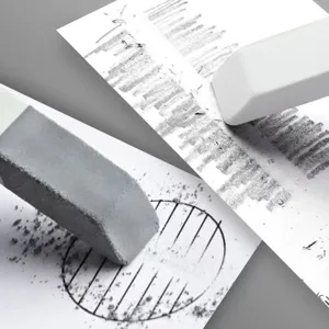 Detail shot of abrasive eraser removing pencil marks cleanly with visible texture and shavings.
