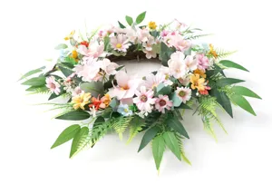 Detailansicht des Frühlings Kunstkranzes, rosa Blüten und grüne Blätter auf Rebenbasis.