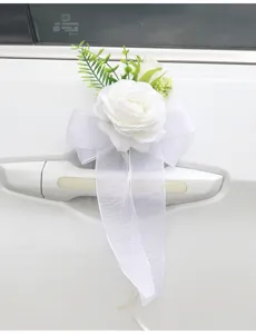 Wedding car door handle artificial rose flower and white bow detail close up shot.