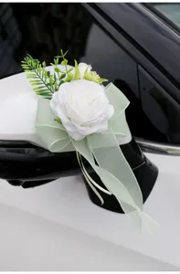 Artificial white rose car mirror flower wedding decoration with green bow and leaves.