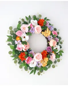 Detailed view of artificial floral wreath with colorful peonies, roses and eucalyptus leaves.