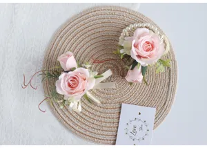 Nahaufnahme der künstlichen rosa Rosen-Armbandblumen mit Perlenkette und feinem Band.