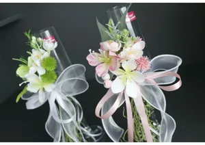 Hochzeit Sektglas dekorativer künstlicher Blumenstrauß mit Bändern für Feierlichkeiten.