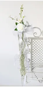 White artificial rose chair back flower detail for wedding party, elegant floral decor.