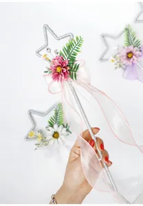 Dettaglio bacchetta magica stella con fiore rosa e nastro per accessorio festa cosplay.