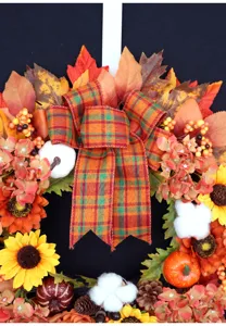 Detailansicht des Herbst Ernte Kranzes mit künstlichen Ahornblättern, Kürbissen und Schleife.