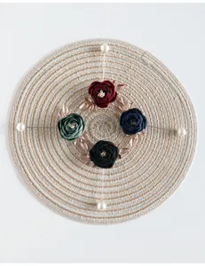 Gedetailleerde close-up van vintage stoffen rozenbloem broche met elegante parelspeld.