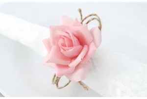 Primo piano dettagliato di un portatovagliolo di rosa artificiale rosa con spago rustico.