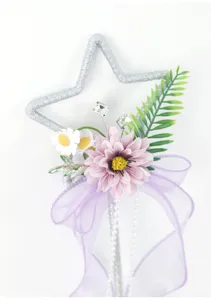 Dettaglio bacchetta magica creativa con stella, fiore rosa e fiocco viola per cosplay.