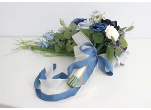 Künstlicher Rosen Brautstrauß Detailansicht mit kaskadierenden blauen weißen Blumen Schleifen.