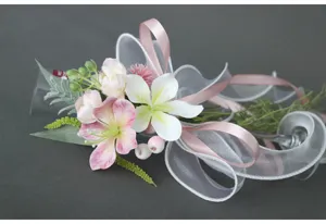 Detailaufnahme von künstlichen Blumen mit zarten rosa Blüten und edlen Schleifen.