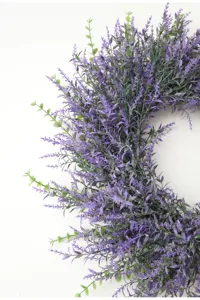 Detailed close-up view of artificial lavender wreath showing rich purple floral texture and leaves.