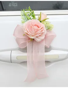 Detailed shot of pink artificial rose flower with sheer bow for wedding car door handle decor.