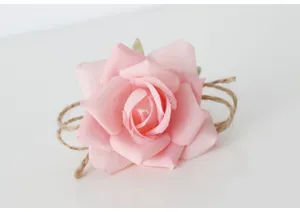 Primo piano dettagliato di un grazioso anello portatovagliolo rosa con corda di juta.