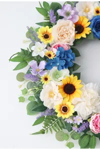 Close-up detail of colorful artificial floral wreath with sunflowers and roses for wall decor.