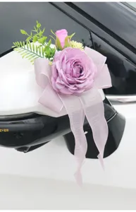 Detailed view of purple artificial rose wedding car mirror decoration flower with ribbon bow.