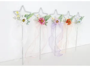 Primo piano della bacchetta magica a stella con fiori artificiali e nastri per cosplay.