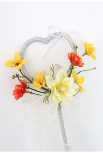 Detailaufnahme eines magischen Feenstabes mit Herzrahmen, künstlichen Blumen und Schleife.