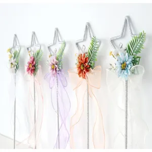 Vista dettagliata di bacchette magiche a stella con fiori artificiali e nastri colorati per cosplay.