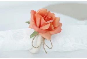 Portatovaglioli in legno con rosa artificiale pesca e spago per decorazione tavola nozze.