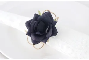 Portatovaglioli con rosa artificiale blu scuro e corda di juta per elegante decorazione tavola.