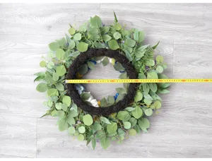 Artificial floral wreath detail view, showing size and texture for home wall decor and events.