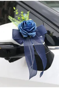 Detail shot of blue artificial rose wedding car mirror decorative flower with dark blue bow.