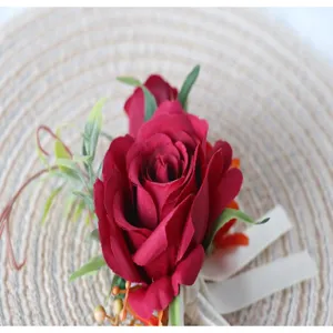 Burgunderrote künstliche Rosen Hochzeits-Corsage Detailaufnahme mit grünen Blättern Dekor.