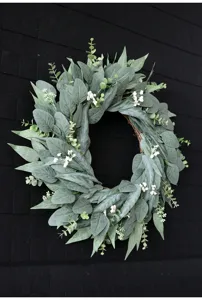 Vista detallada de corona de eucalipto artificial con pequeñas flores para decoración.