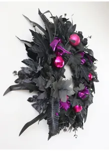 Detailed view of black artificial Halloween wreath with pink ornaments for door decor.
