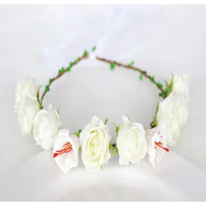Detailed view of the white floral crown headband with artificial roses and ribbon accents.