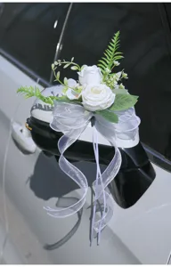 Artificial flower wedding car rearview mirror decoration white rose bow ribbon bouquet detail view.