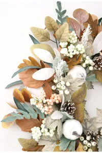 Detail shot of autumn Thanksgiving artificial maple leaf pinecone white pumpkin decorative wreath.