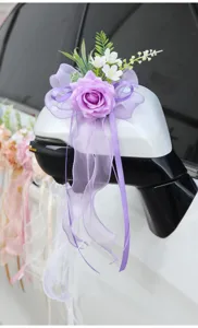 Close-up view of wedding car rearview mirror flower decoration with purple rose and bow.