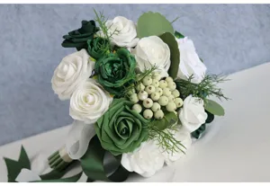 Detailaufnahme eines weiß-grünen künstlichen Rosen-Brautstraußes mit Beeren für Hochzeitsdekoration