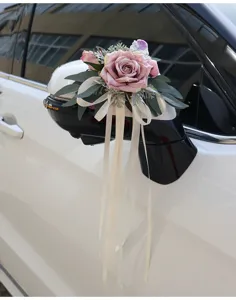 Wedding car mirror artificial rose flower decoration with elegant white ribbons and green leaves.