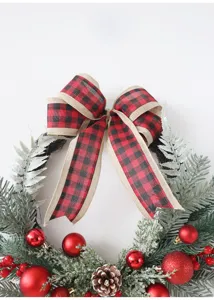 Ghirlanda di Natale con fiocco scozzese, pigne e palle rosse per decorazione della porta di casa.