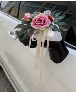 Detailed shot of wedding car rearview mirror artificial rose flower decoration with white ribbons.