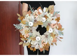 Detail shot of autumn Thanksgiving maple pine cone wreath with white pumpkins, perfect for door decor.